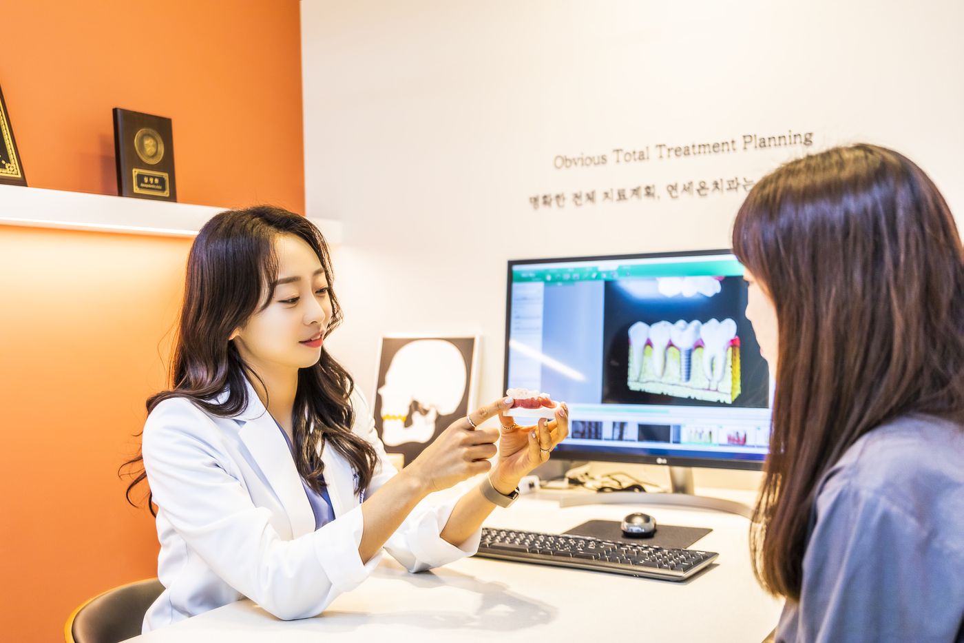 김경희 대표원장이 치아 모형으로 치료를 설명하는 상담 장면